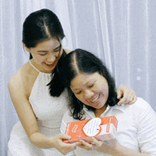 a woman is holding a box that says " i love you "