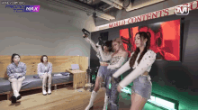 a group of girls are dancing in front of a wall that says world contents