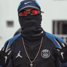 a man wearing sunglasses and a jacket that says paris on the front