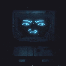 a computer monitor with a glowing face on it is sitting in the dark .