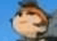 a blurred image of a person 's face with a blue sky in the background .