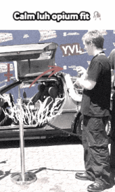 a man is standing in front of a car that says yvl