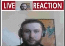 a man with a beard is wearing headphones and a live reaction sign .