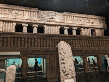 a statue of a woman stands in front of a building with columns