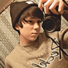 a young boy is taking a picture of himself in a mirror with a camera .