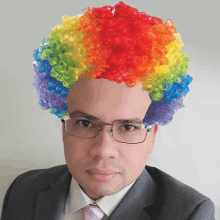 a man wearing glasses and a rainbow clown wig