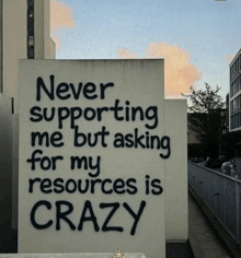 a sign on a wall that says never supporting me but asking for my resources is crazy