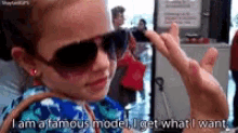 a little girl wearing sunglasses is saying i am a famous model i get what i want