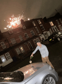 a man is pouring a bottle of champagne into a car