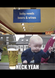 a baby sitting at a table with a glass of beer and a sign that says baby needs beers and wines