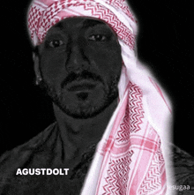 a man with a scarf around his head has the name agustdolt on the bottom right