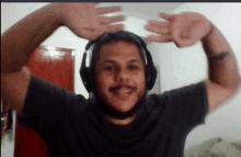 a man wearing headphones is making a funny face with his hands in the air