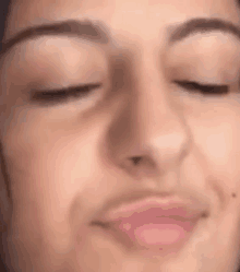 a close up of a person 's face with their eyes closed and a pink lip .