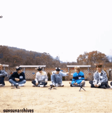 a group of young men are sitting on the ground with their legs crossed and the words sunsunarchives on the bottom