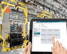 a person is holding a tablet in a factory and using it .