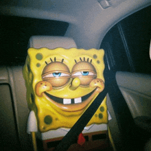 a statue of spongebob sits in a car seat