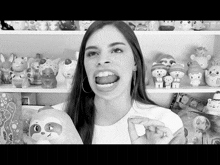 a woman is holding a stuffed animal in front of a shelf full of toys