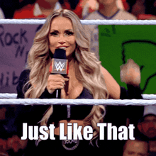 a woman in a wrestling ring is holding a microphone and the words just like that are above her