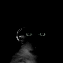 a close up of a person 's eyes with headphones on in the dark