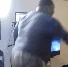 a blurry picture of a man standing in front of a computer