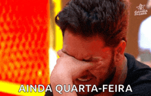 a man covering his face with his hand and the words " ainda quarta-feira " written below him