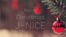 a christmas tree with a red ornament and the words merry christmas j-nice below it