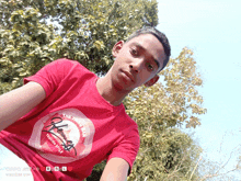 a young man wearing a red shirt that says " the finest "