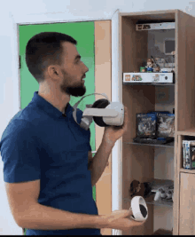 a man wearing a virtual reality headset is standing in front of a shelf with a lego mario box on it