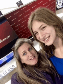 a woman and a girl are posing for a picture in front of a sign that says romeo