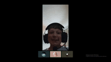 a boy wearing headphones is on a video call with three other people