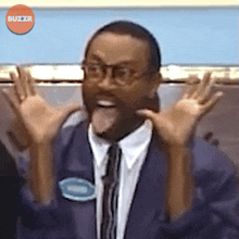 a man in a suit and tie is making a funny face in front of an orange buzzr logo