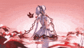 a girl in a white dress is kneeling in the water with red flowers