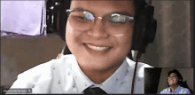 a man wearing glasses and headphones is smiling in a video call with another man