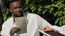 a man in a white shirt is holding a piece of paper that says ' dinner of the day '