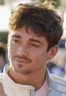 a close up of a man with a beard wearing a white jacket