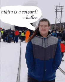 a man in a blue jacket stands in the snow with a speech bubble that says nikita is a wizard