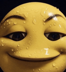 a close up of a yellow smiley face with water drops on it 's face