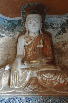 a statue of a buddha with a painting behind it