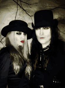 a man and a woman are standing next to each other wearing top hats