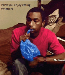 a man in a red shirt is eating a blue bag