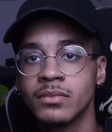 a close up of a man wearing glasses and a baseball cap