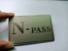 a person holding a card that says n-pass