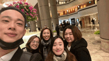 a group of people are posing for a photo in a lobby