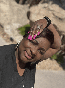 a woman with long pink nails and a watch on her wrist