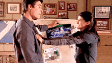 a man and a woman are standing in front of a refrigerator that has a sign on it that says ' besturing '