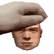 a hand is holding a man 's head with a beret on it .