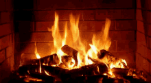 a fire is burning in a brick fireplace with logs in it