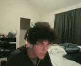 a man wearing headphones is sitting in front of a bed
