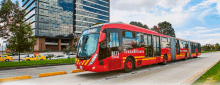 a red bus that says transmilenio on the side of it