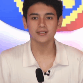 a young man wearing a white shirt with a microphone on his neck